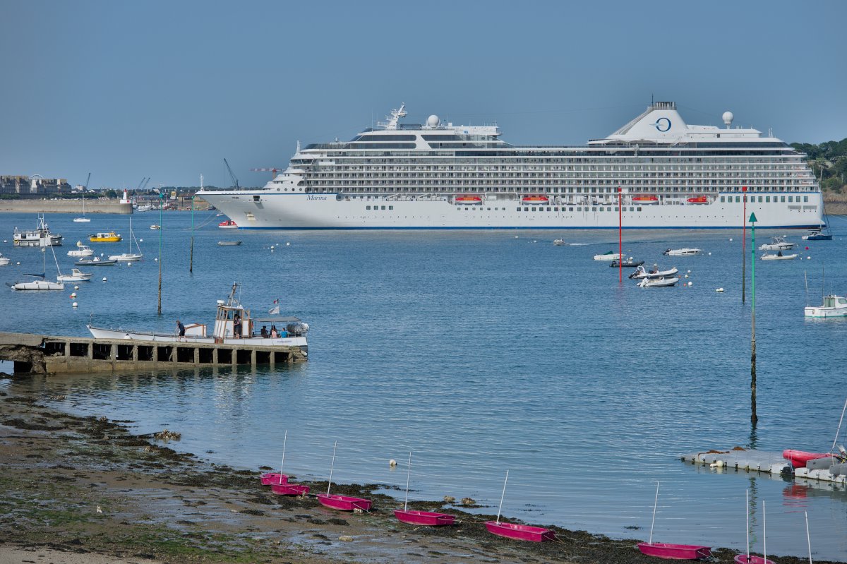 Le paquebot Marina au mouillage devant Saint-Malo, optimists roses échoués au premier plan.